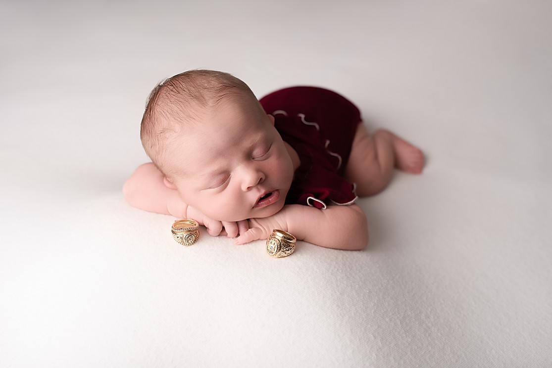 newborn baby girl, in home newborn photography, newborn baby girl in red romper with class rings, newborn photography San Diego