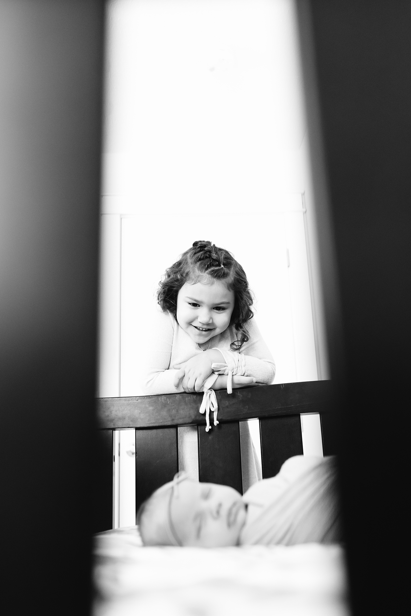 newborn baby in crib and older sister looking in, Lauren V Photography San Diego newborn photographer