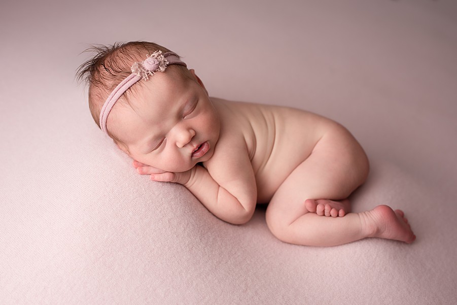 newborn baby girl on pink with headband on, lauren v photography, san diego newborn photographer