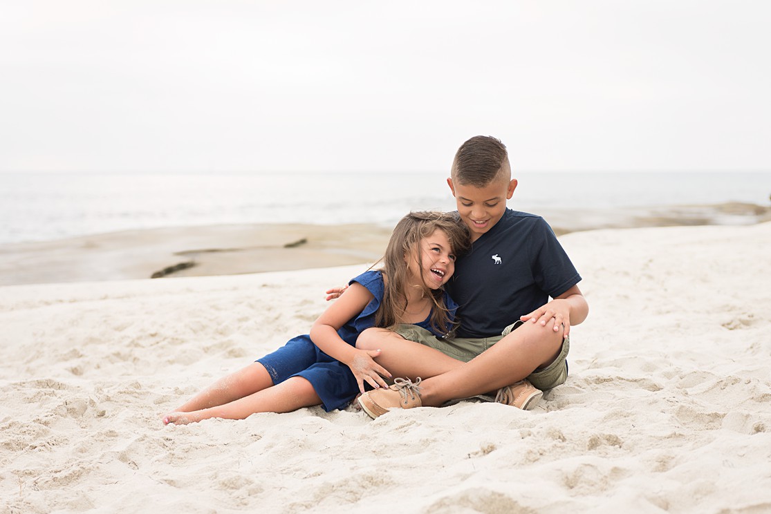 brother and sister sitting on the beach at Windansea beach, Lauren V Photography San Diego photographer